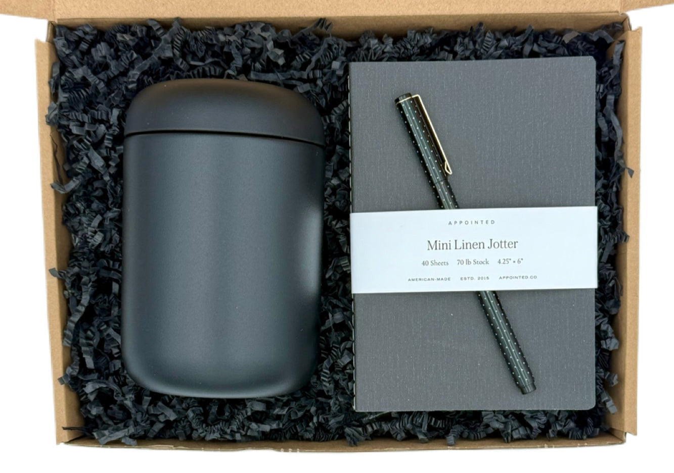 Set of gray mug, notebook, and pen in a gift box