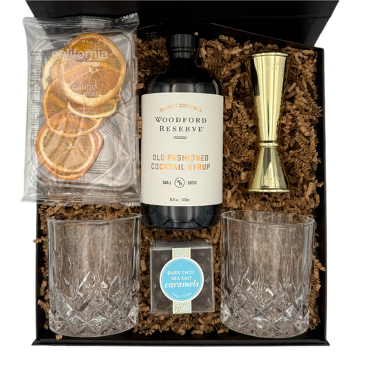 Gift set with Woodford Reserve syrup, glasses, and a jigger in a box.