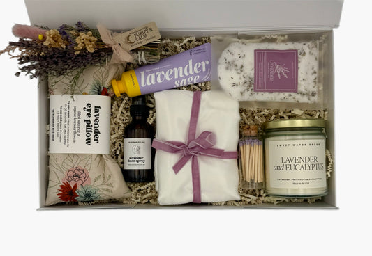 Gift set with lavender-themed products including a candle, soap, and bath salts.