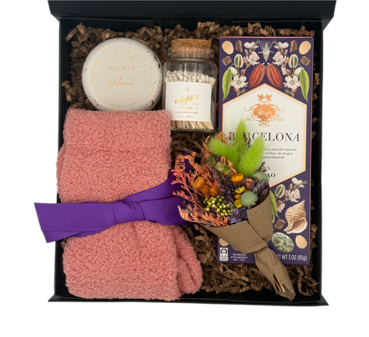 Gift set with pink towel, soap, and decorative items in a box