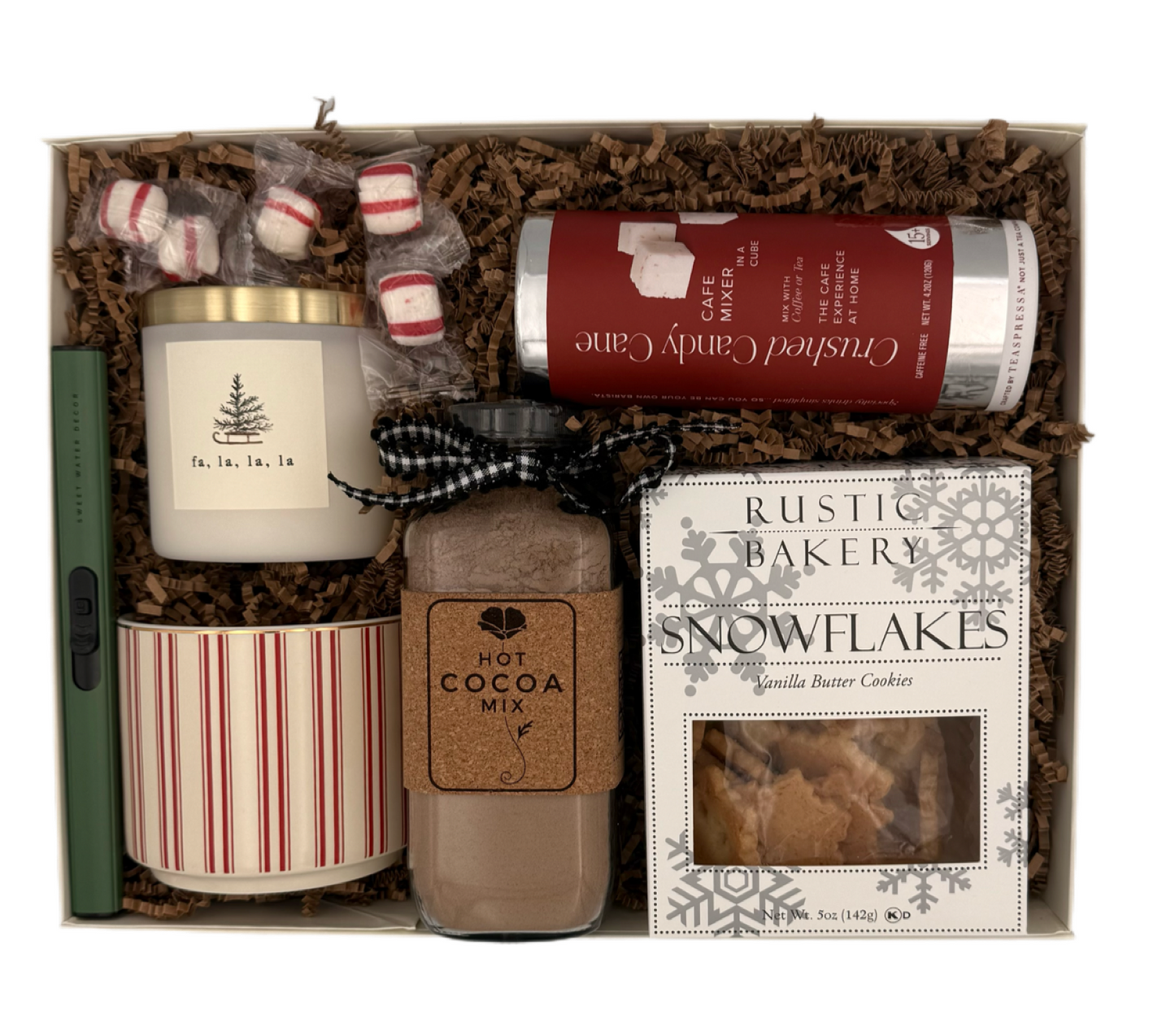 Gift set with a candle, hot cocoa mix, and cookies in a decorative box.