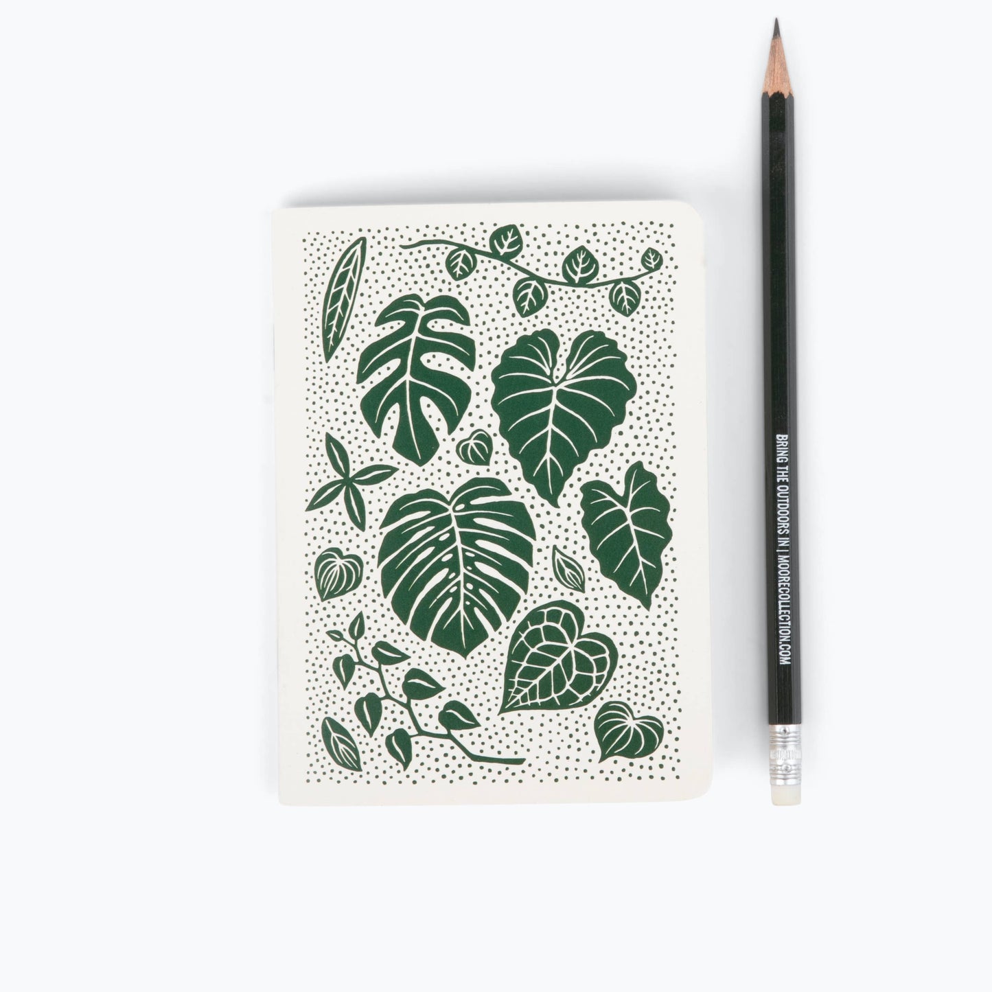 Notebook with green leaf pattern and a pencil on a white background