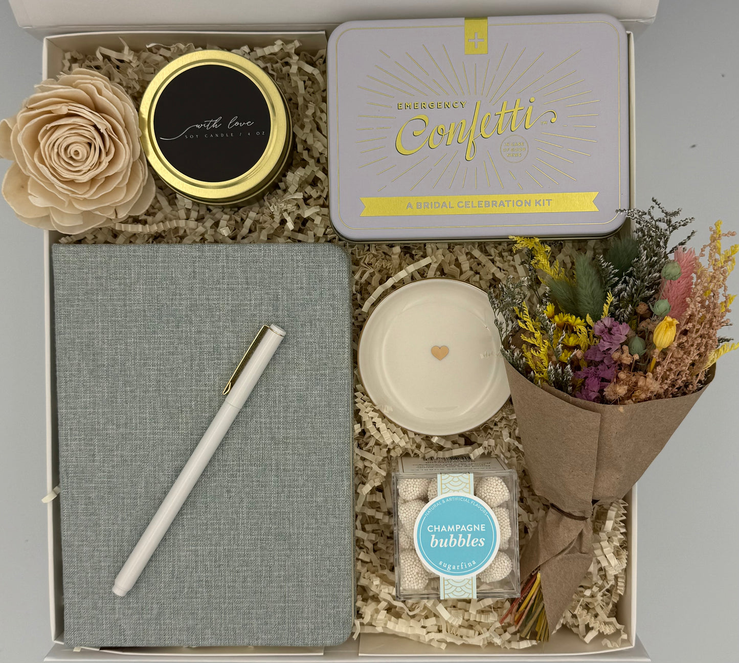 Gift box with a notebook, pen, candle, and decorative items for bridal party