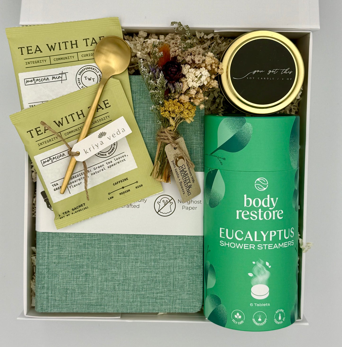 Gift set with tea packaging, a spoon, and a shower steamer in a box.
