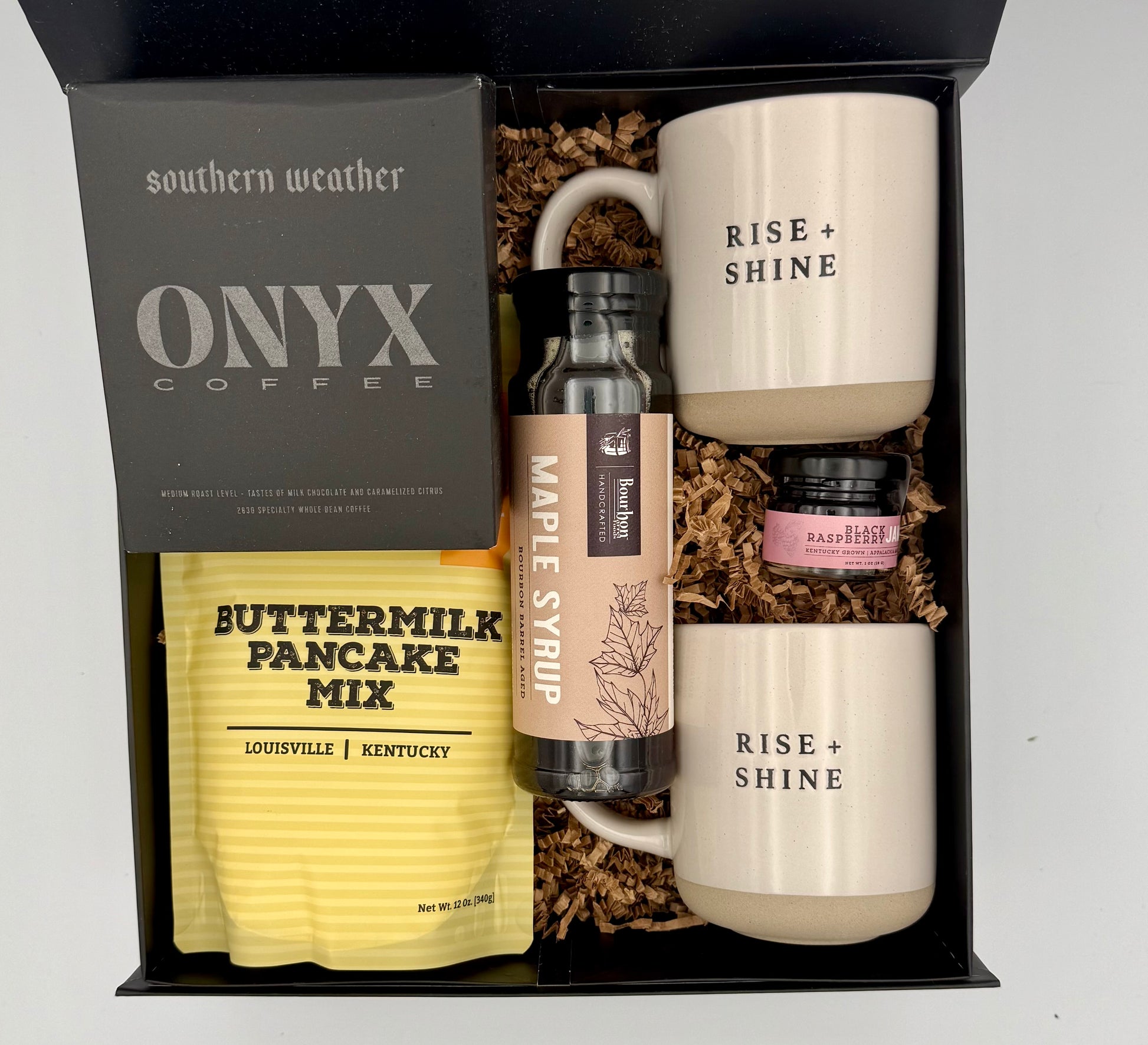 Gift set with mugs, coffee, pancake mix, and syrup in a box labeled 'southern weather ONYX COFFEE'.