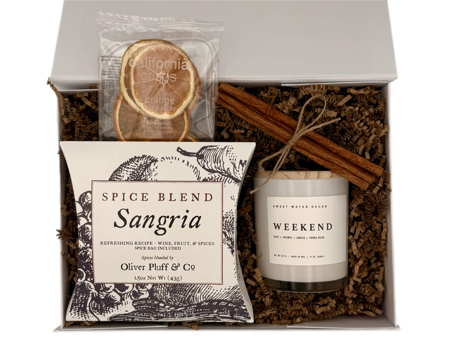 Gift set with a candle, spice blend, and cinnamon sticks in a box.