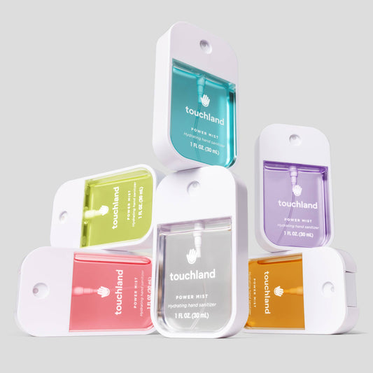 Collection of Touchland hand sanitizer packets in various colors on a gray background