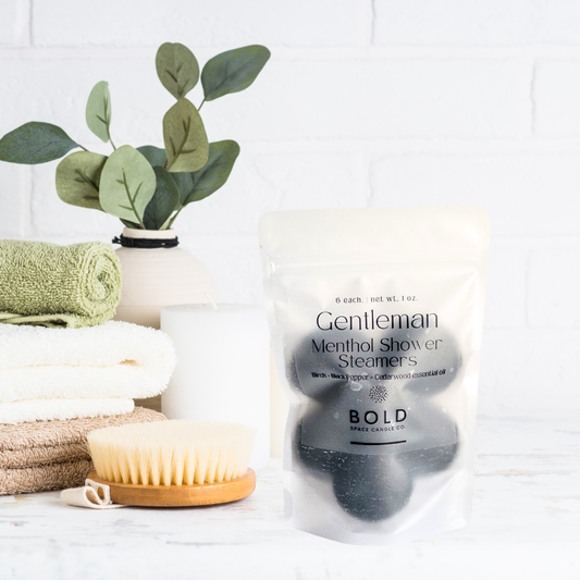 Gentleman Menthol Shower Steamers packaging with a plant and towels on a white background