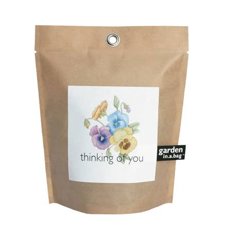 Kraft paper bag with a floral design and text 'thinking of you' on a white background