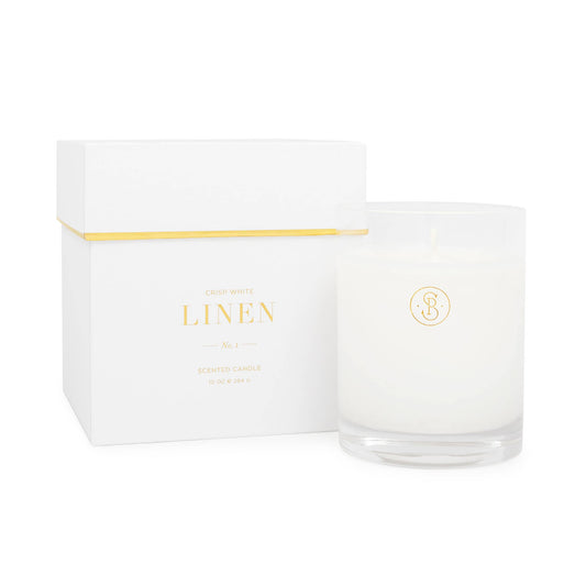 White candle in a glass jar with a white box labeled 'LINEN' on a white background