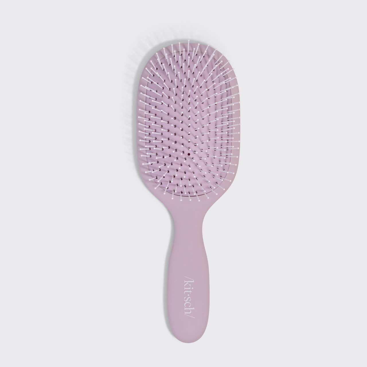 Pink hairbrush with 'kittsky' branding on a light gray background