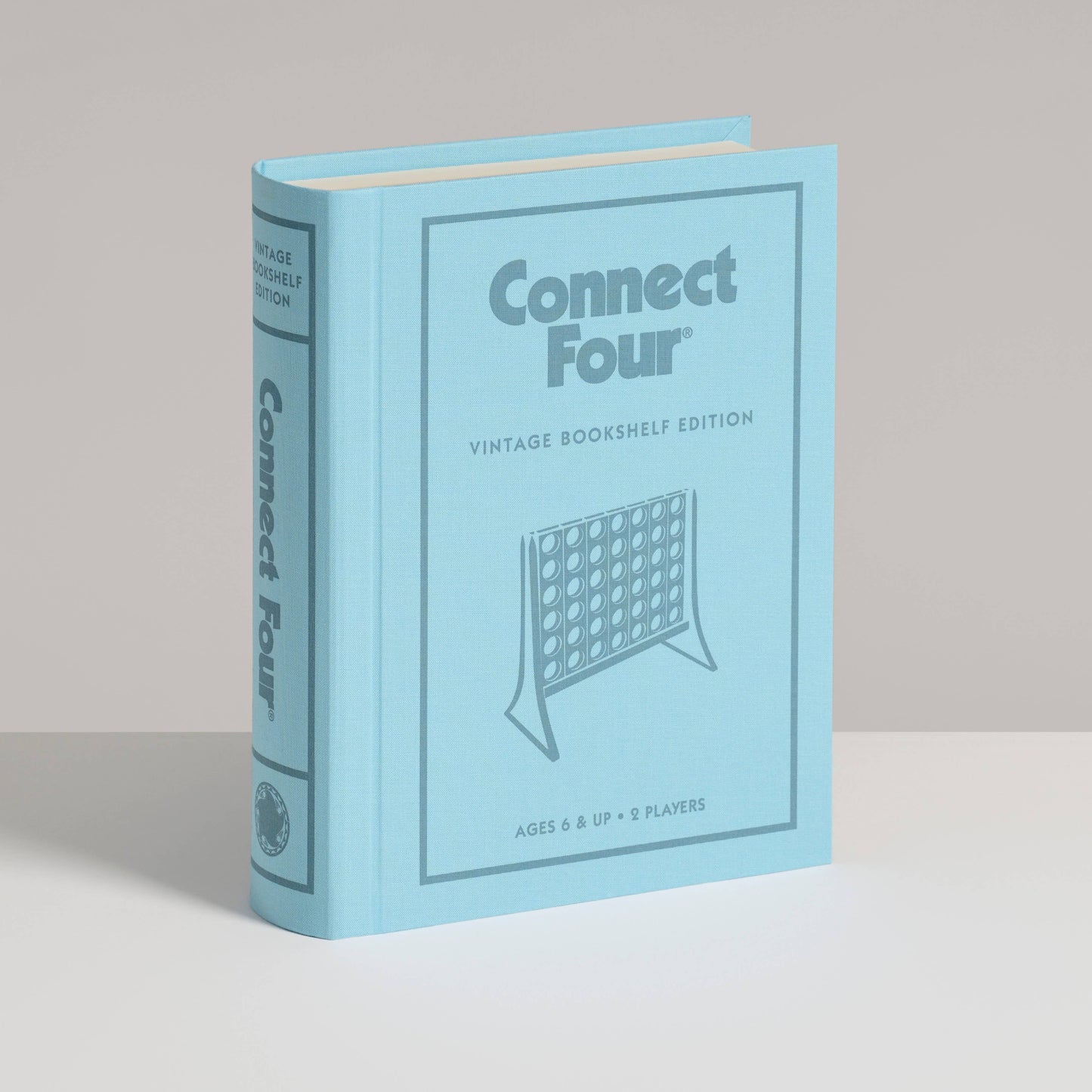 Blue book-shaped packaging for Connect Four vintage bookshelf edition on a beige background