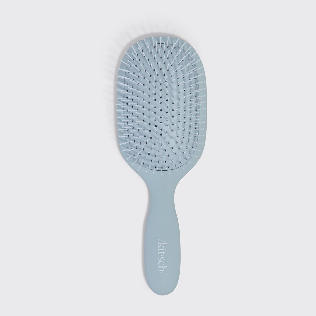 Blue hairbrush on a light gray background