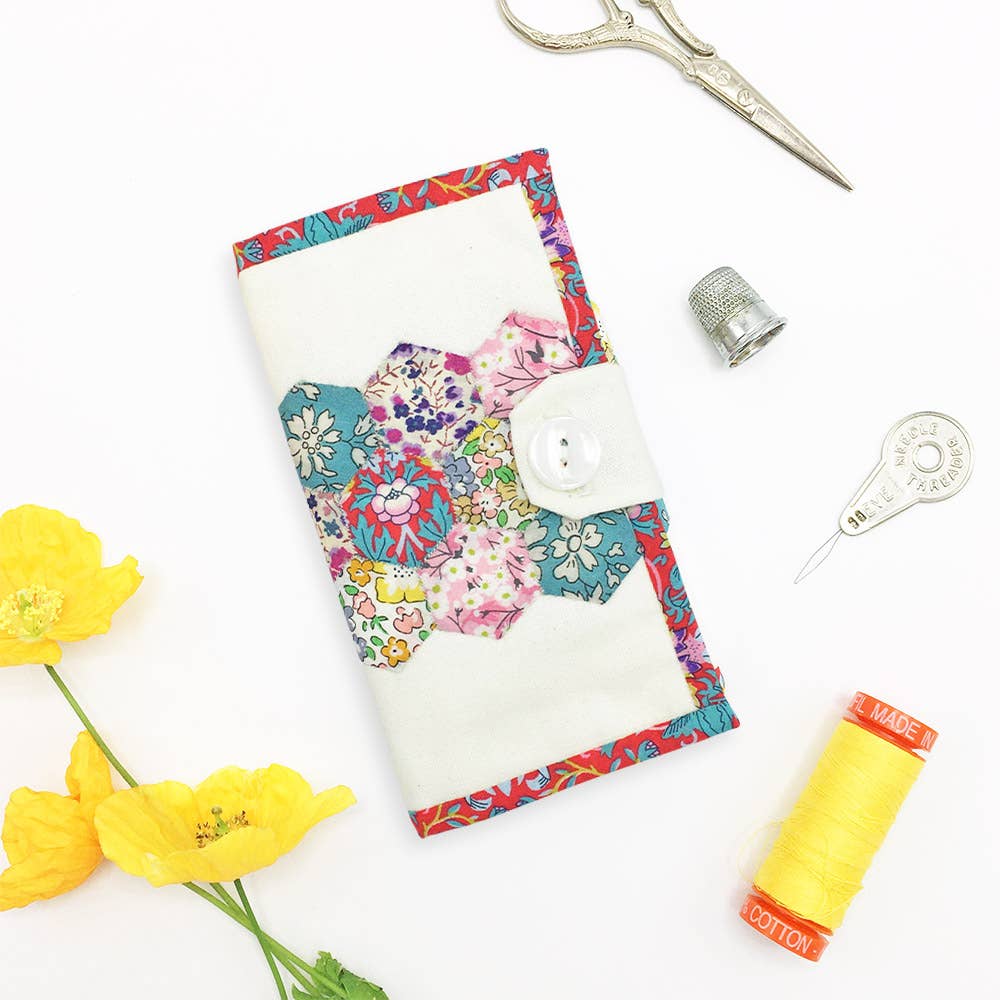 Floral fabric with sewing tools and materials on a white background