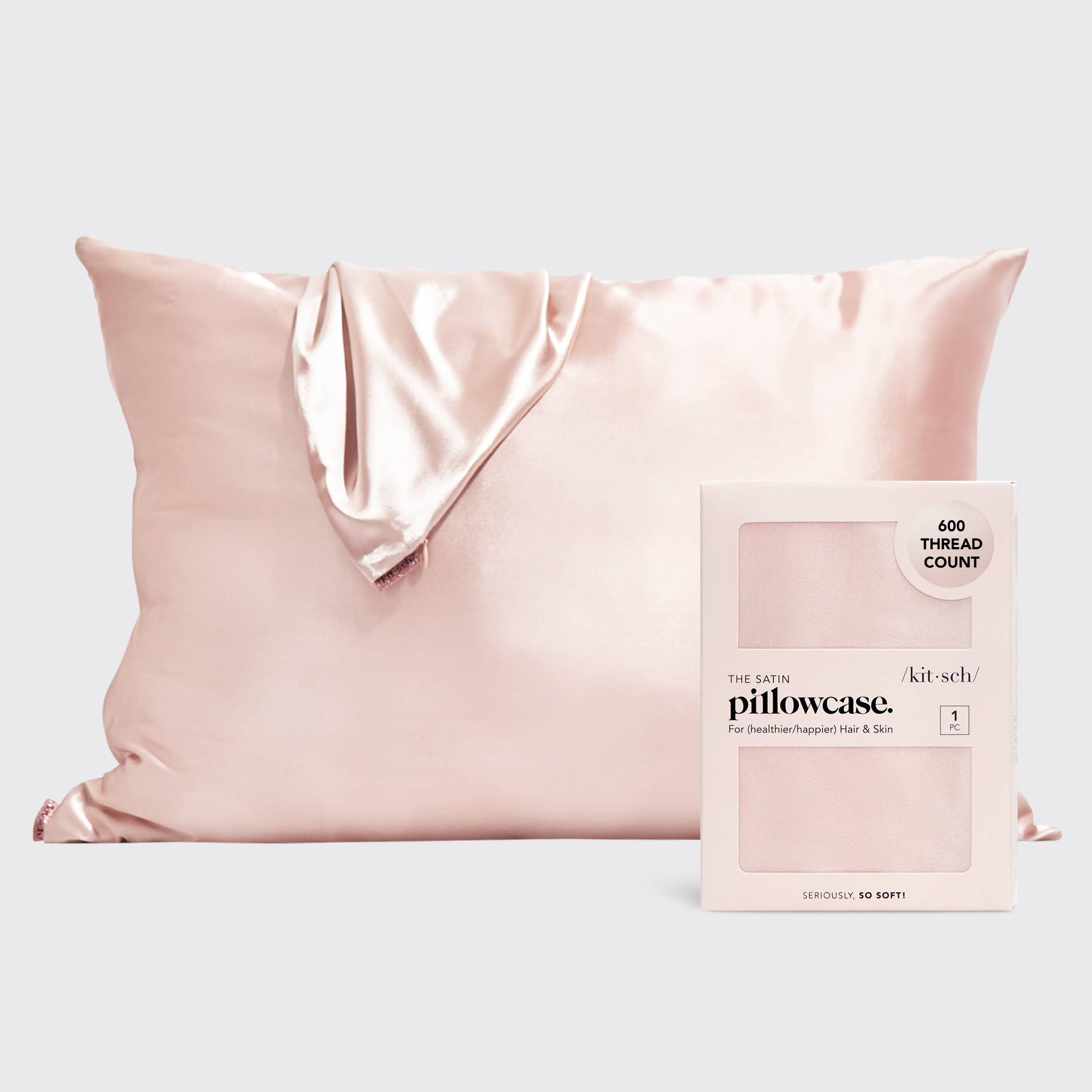 Pink satin pillowcase with packaging on a light gray background