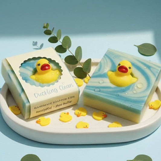 Handmade soap for kids with a rubber duck design on a white tray with green leaves.