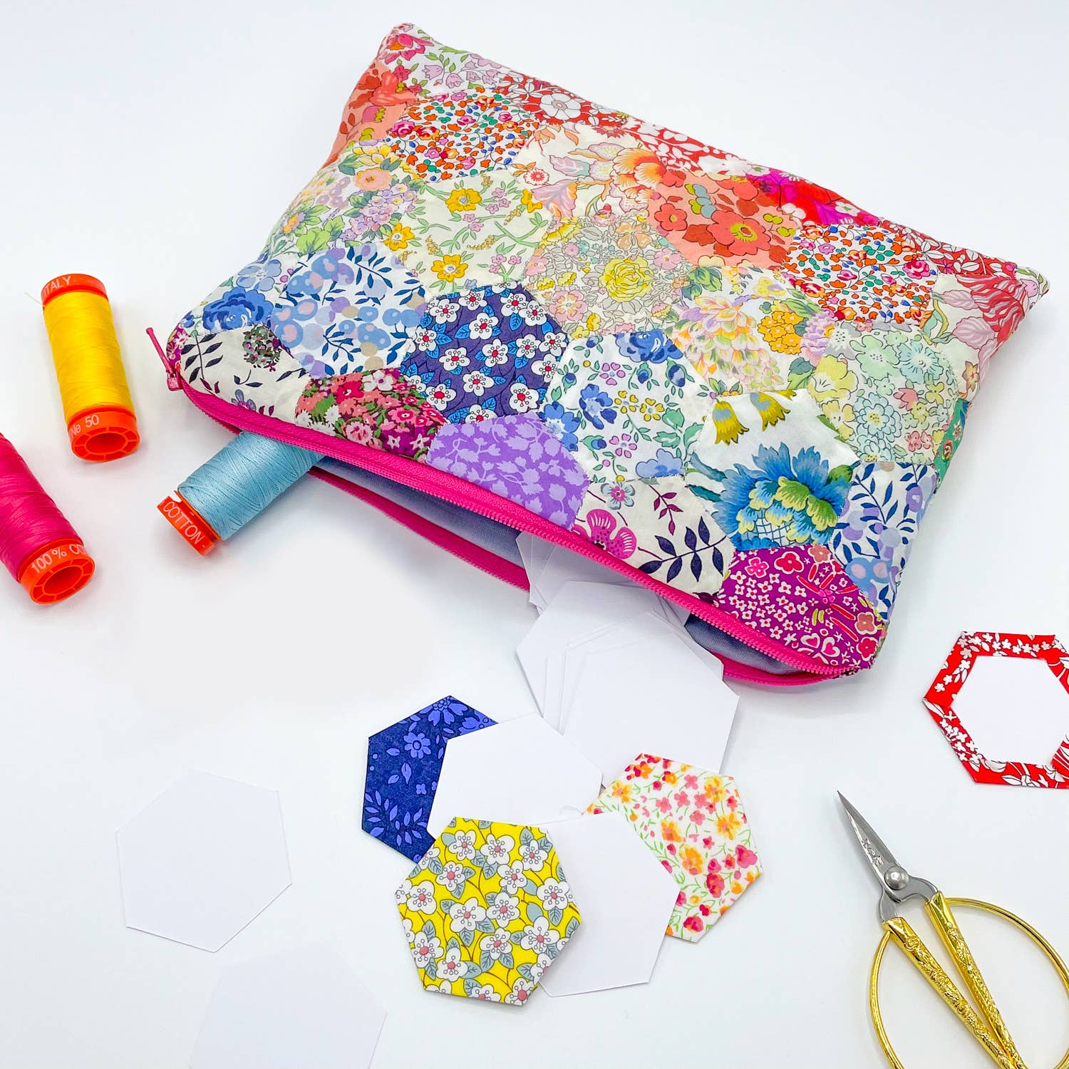 Floral-patterned sewing kit with scissors and thread on a white background