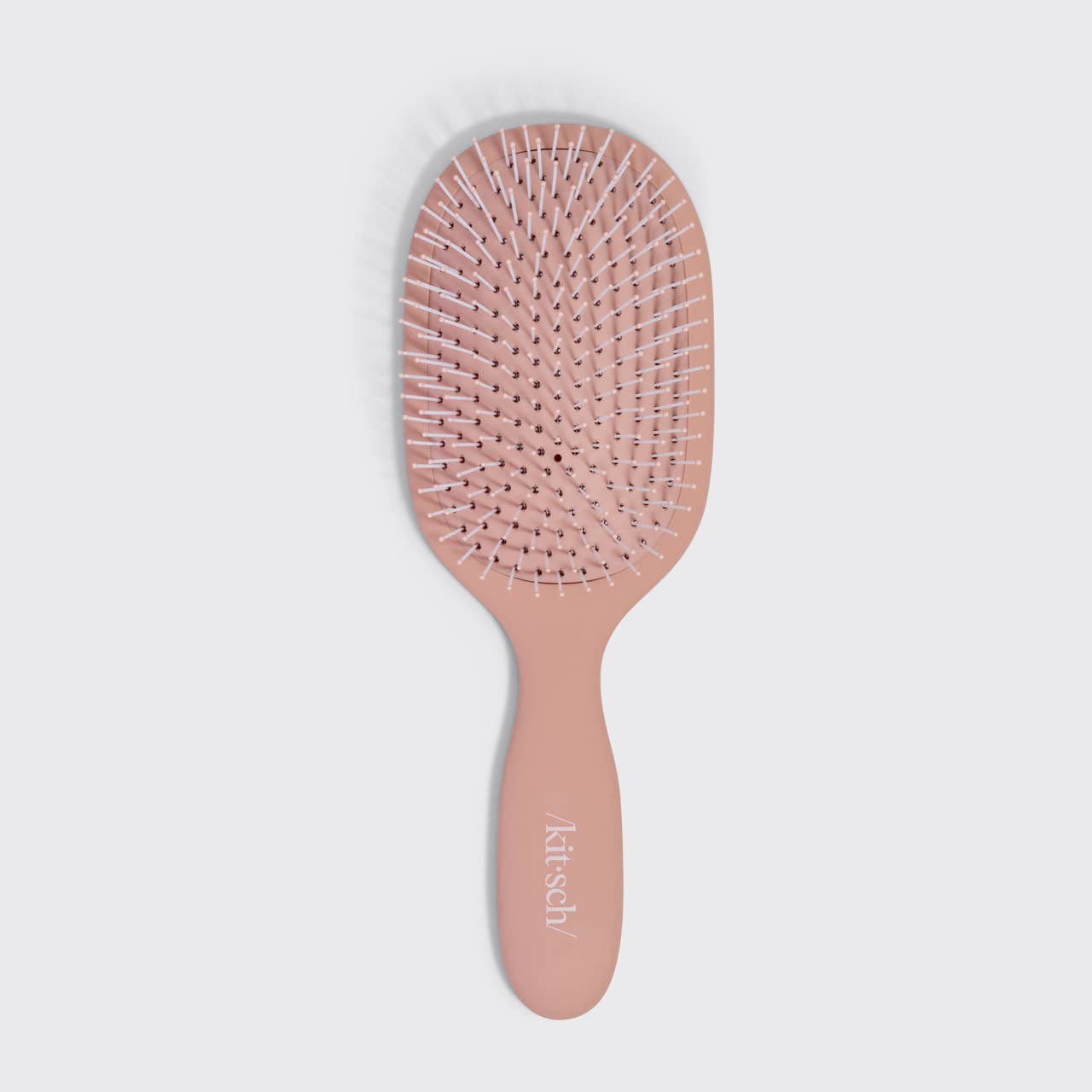 Pink hairbrush with 'Klutch' branding on a light gray background