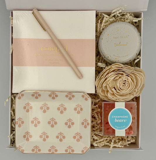 Gift set with a notebook, pen, soap, and decorative items in a box.