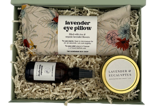 Gift set with lavender eye pillow, essential oil bottle, and candle in a box
