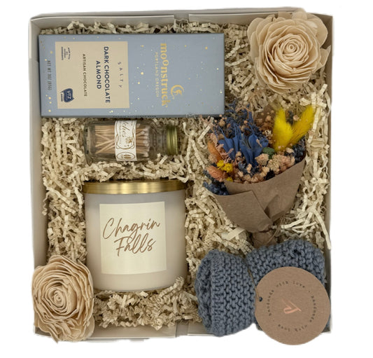Gift set with candle, flowers, and other items in a box