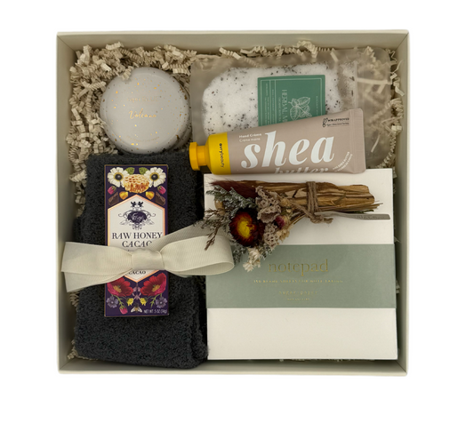 Gift set with bath items including a bath bomb, soap, and bath salts in a box.
