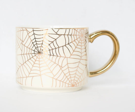 A white ceramic mug featuring a metallic rose gold spiderweb pattern and a polished gold handle, set against a clean white background.