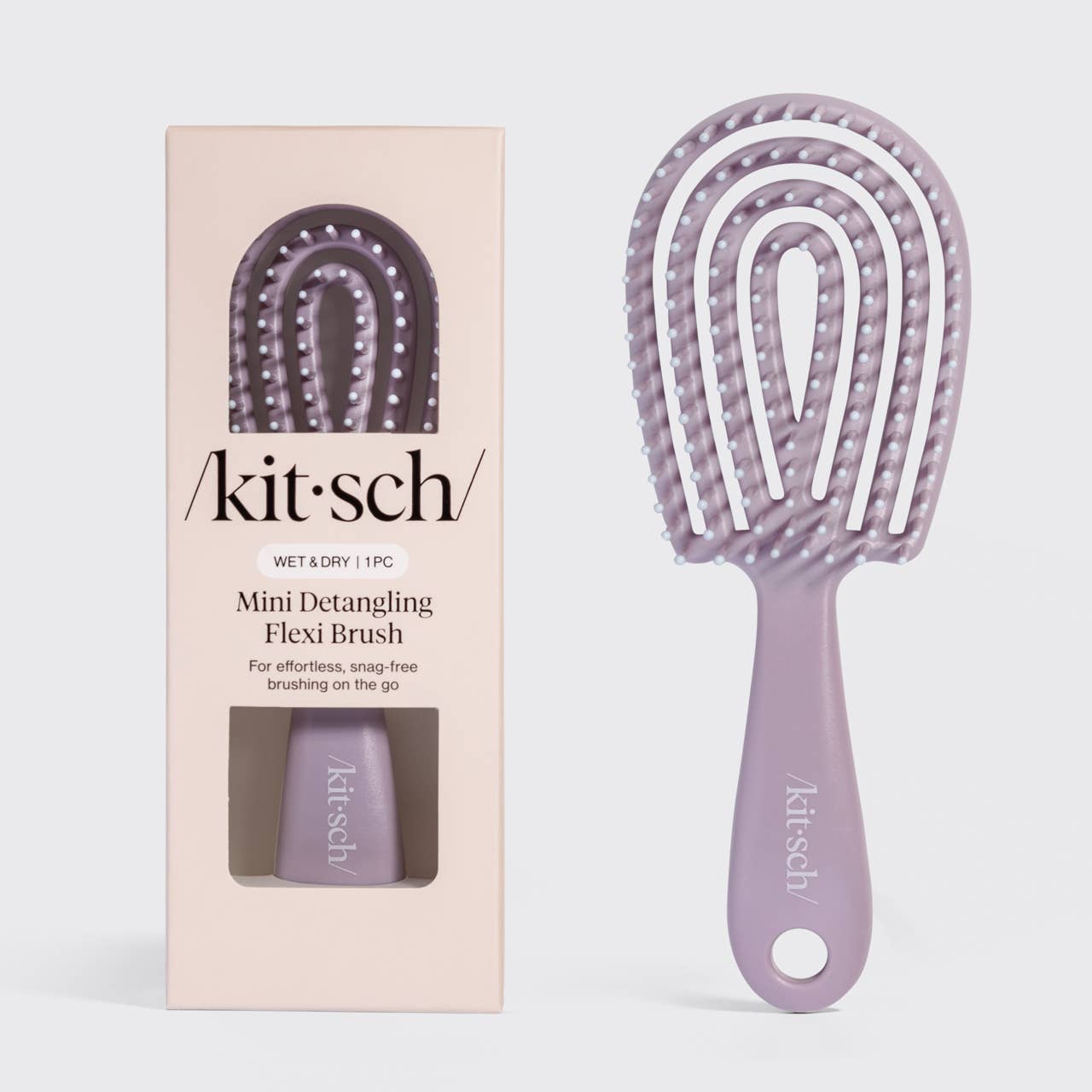 Purple mini detangling flexi brush with packaging on a light gray background