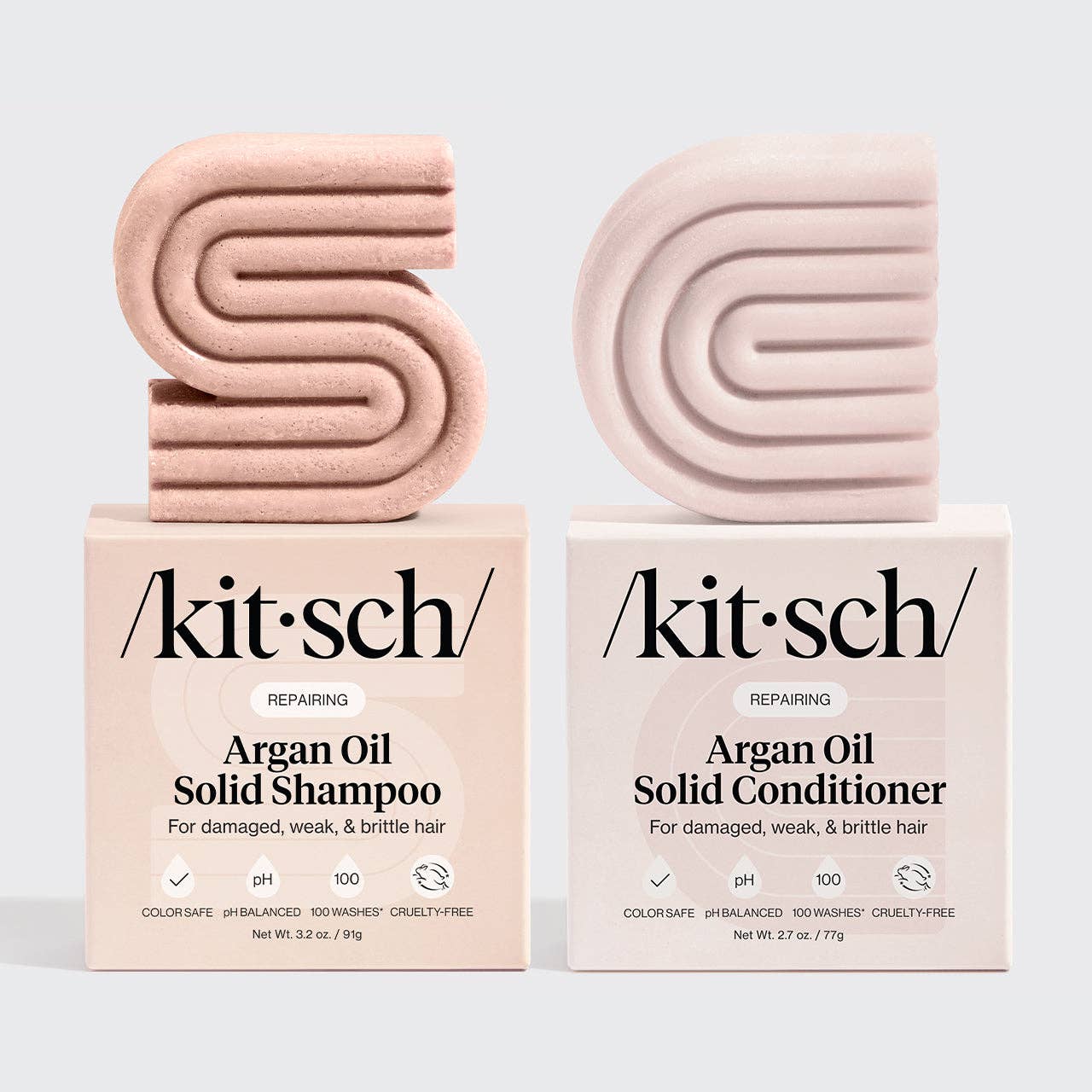 Two pink solid shampoo and conditioner bars with 'kitsch' packaging on a light gray background