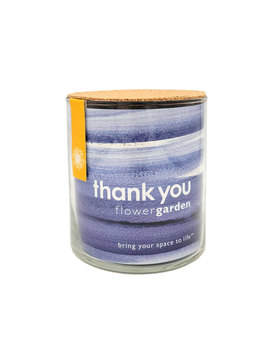 Candle in a glass jar with a striped label on a white background