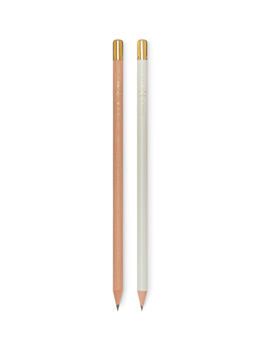 Two pencils, one brown and one white, with gold accents on a white background