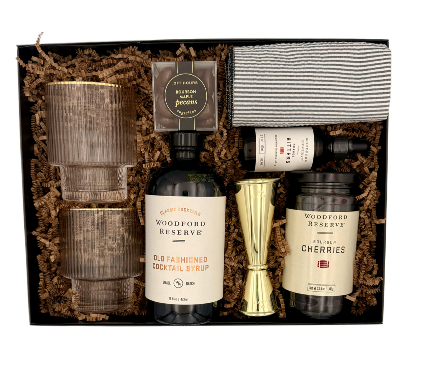 Gift set with Woodford Reserve bottles, cocktail shaker, and cherries in a decorative box.