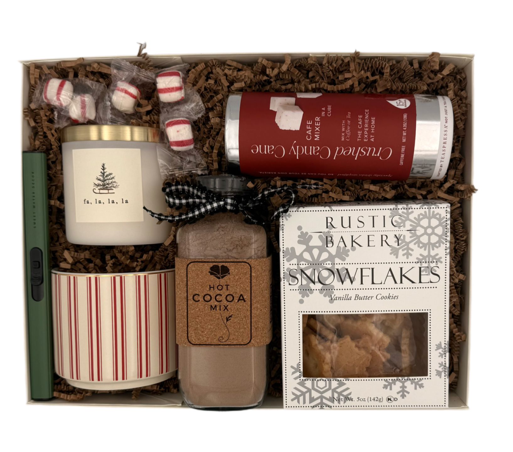 Gift set with a candle, hot cocoa mix, and cookies in a decorative box.