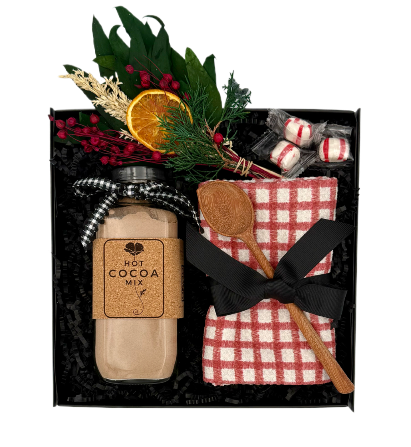 Hot cocoa mix gift set with a jar, spoon, and decorative elements in a black box.