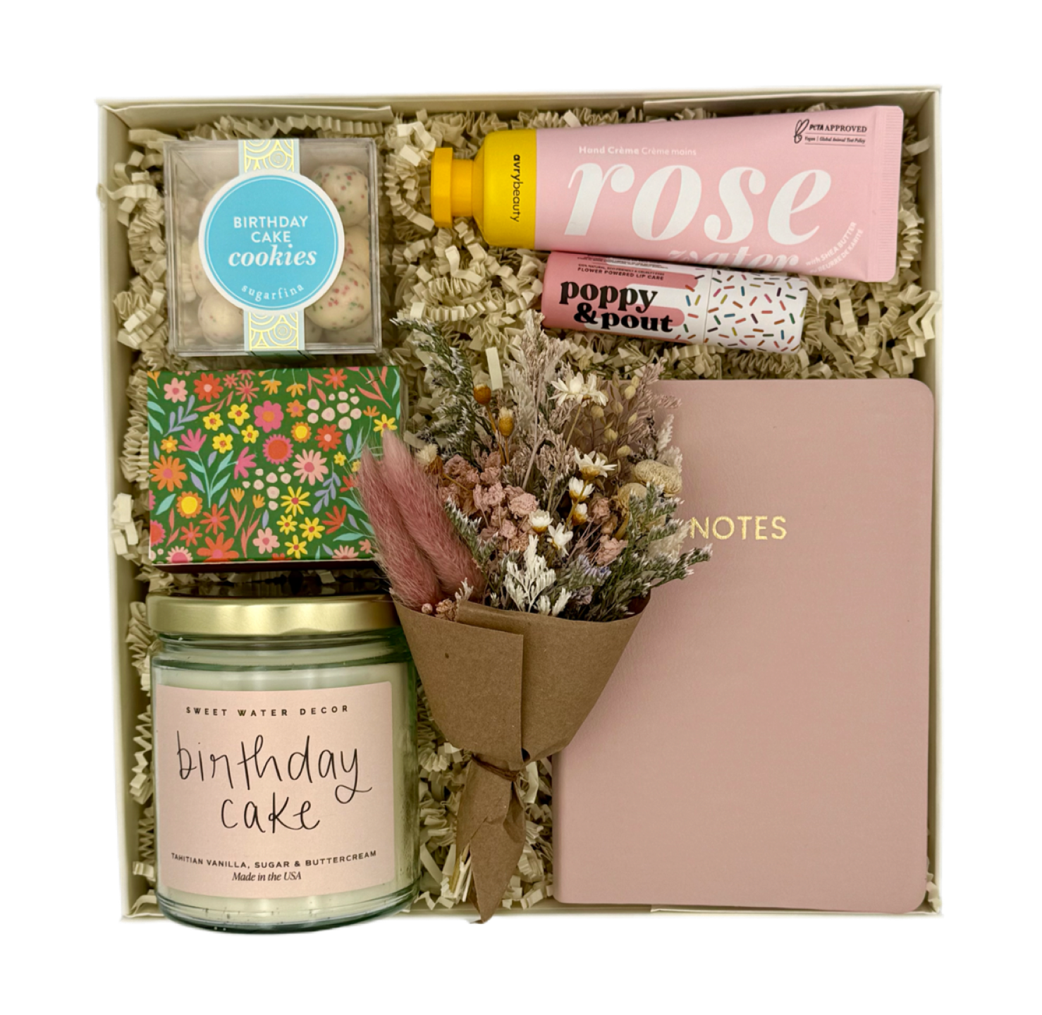 Gift set with candle, cookies, flowers, and notebook in a box