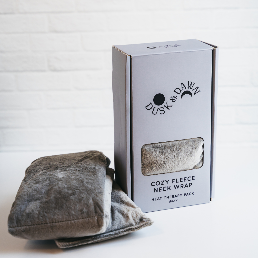 Gray cozy fleece neck wrap with packaging labeled 'Dusk & Dawn' on a white background