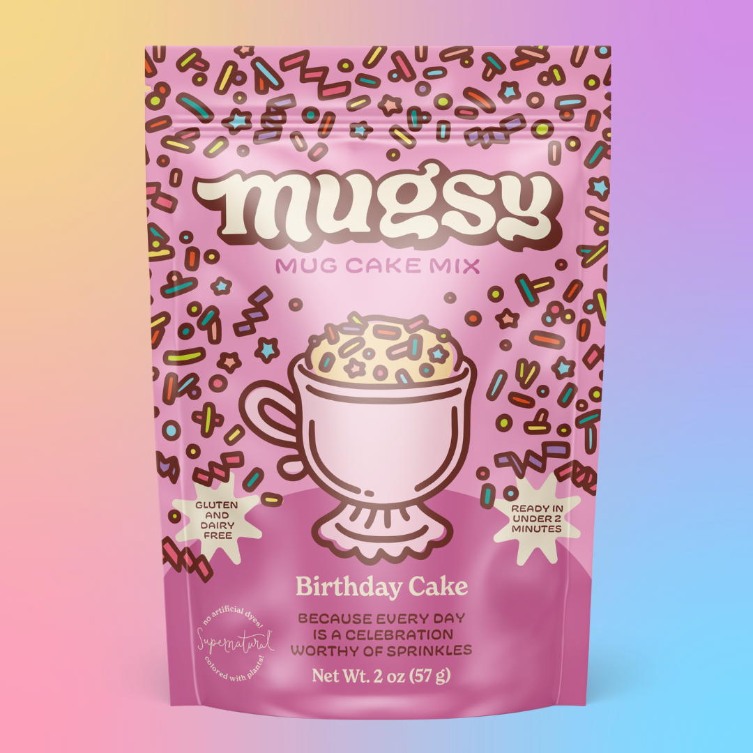 Pink package of Mugsy Mug Cake Mix with birthday cake flavor on a gradient background