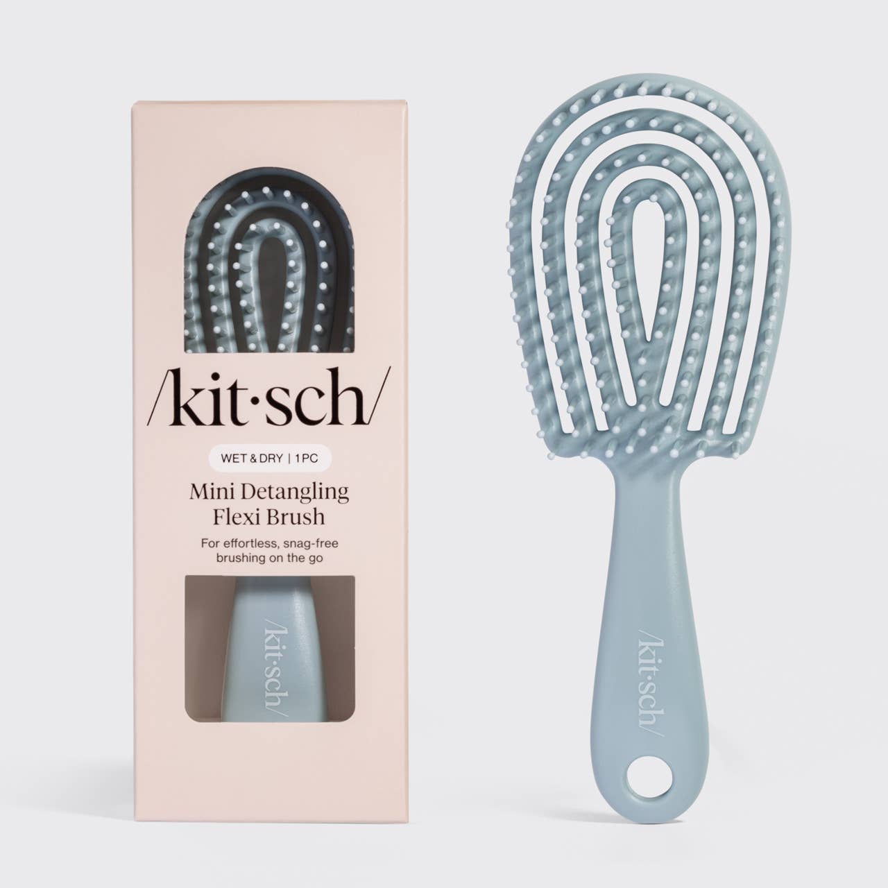 Blue mini detangling flexi brush with packaging on a light gray background