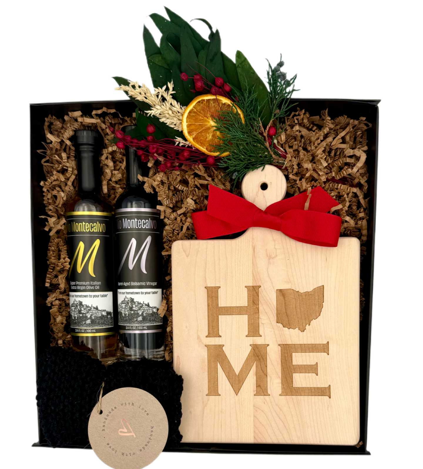 Gift set with Montecarlo bottles, a wooden cutting board with 'HOME' engraving, and decorative elements.