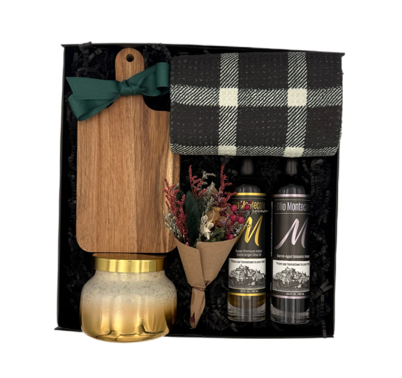 Gourmet gift set with wooden pepper grinder, plaid bag, flowers, and two bottles in a black box.