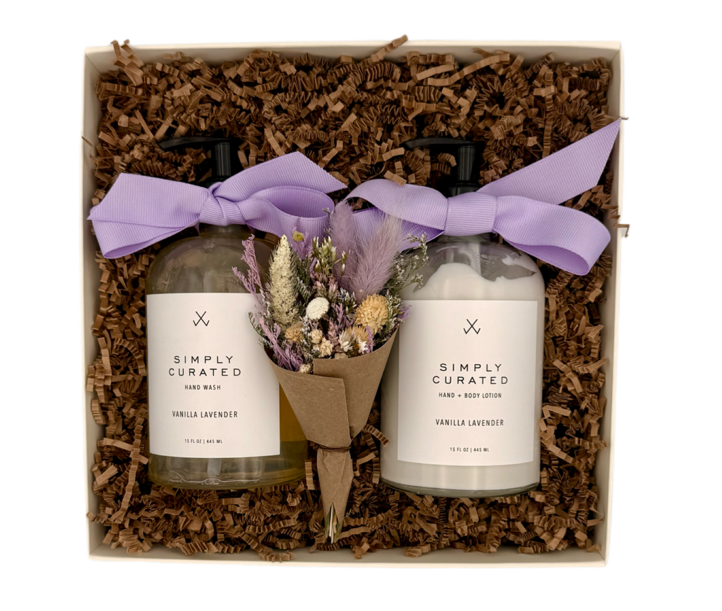Two bottles of 'Simply Curated' body wash and lotion with a small bouquet of lavender in a decorative box.