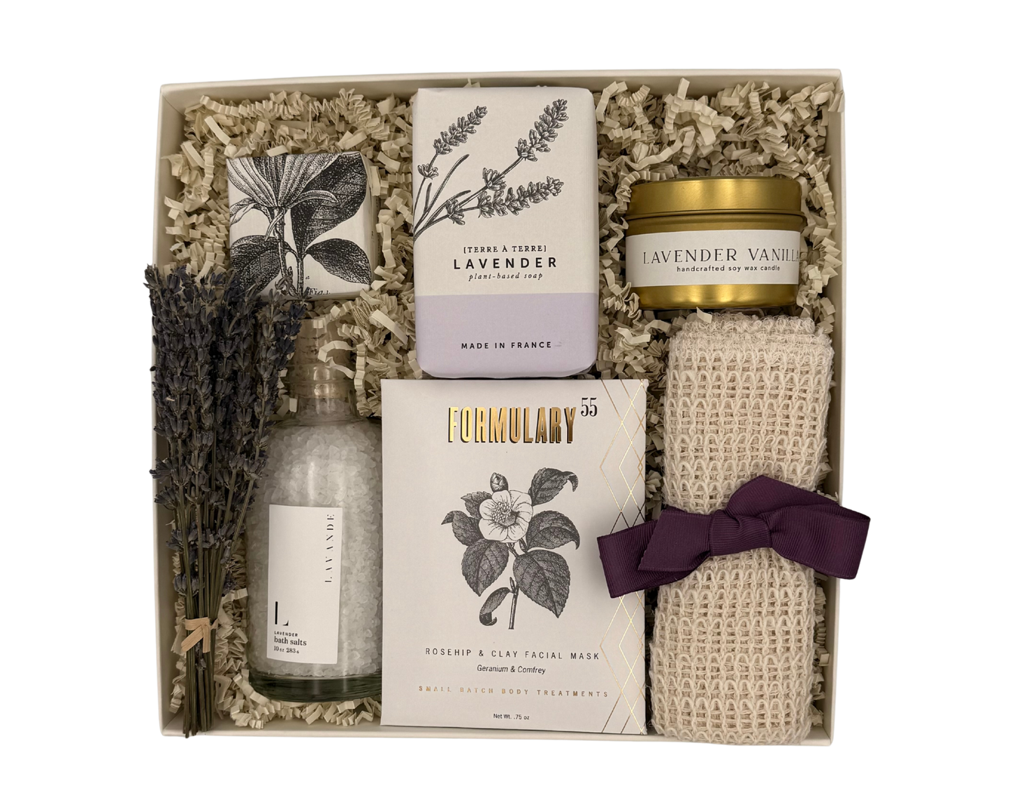 Gift set with lavender-themed products including soap, candle, and towel in a box.
