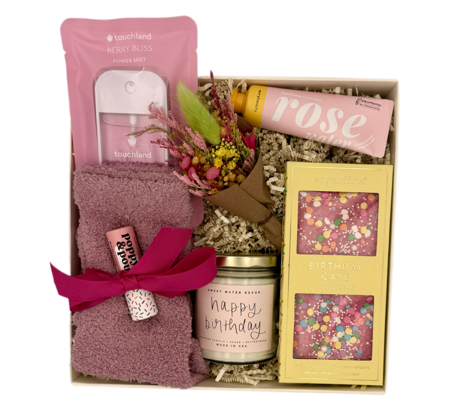 Gift box with socks, candle, and other items on a white background