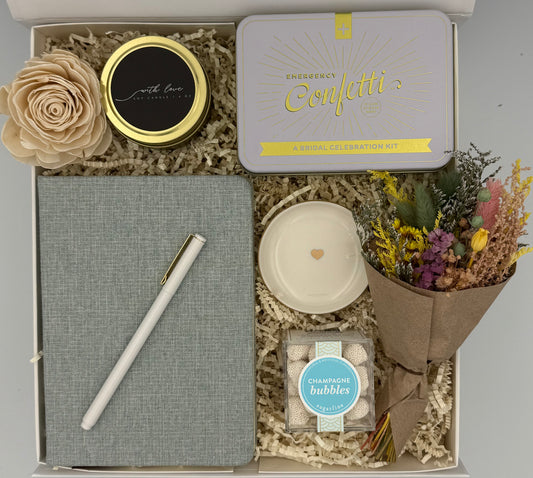 Gift box with a notebook, pen, candle, and decorative items for bridal party