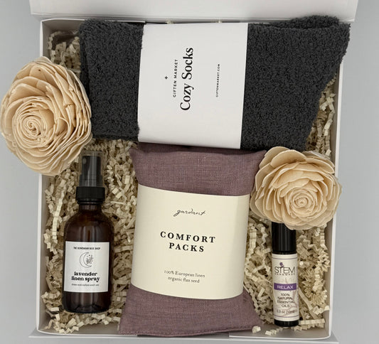 Gift set with socks, lavender linen spray, and essential oil bottle in a box.