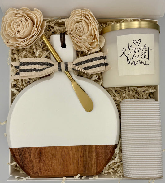 Decorative gift set with a candle, wooden and white vase, and flowers in a box.