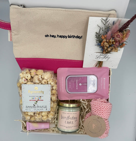 Gift set with a pouch, popcorn, candle, and other items on a gray background