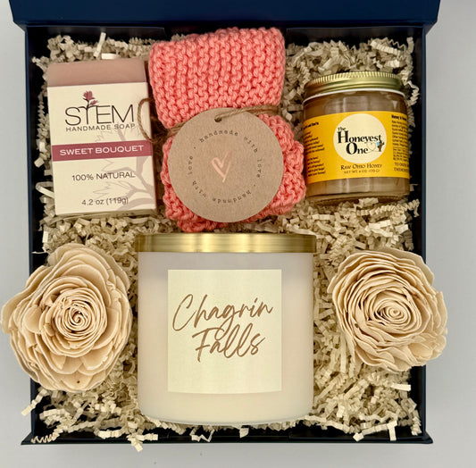 Gift set with candle, soap, and honey in a decorative box.