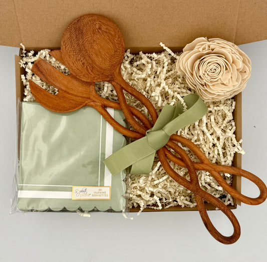 Wooden spoons with a green satin bag and decorative flower in a box