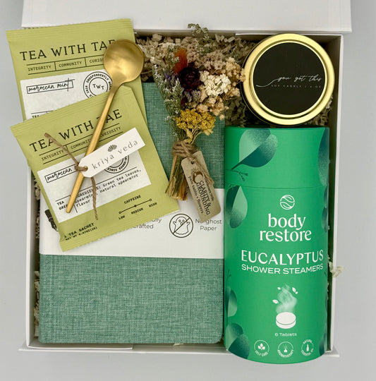 Gift set with tea packaging, a spoon, and a shower steamer in a box.